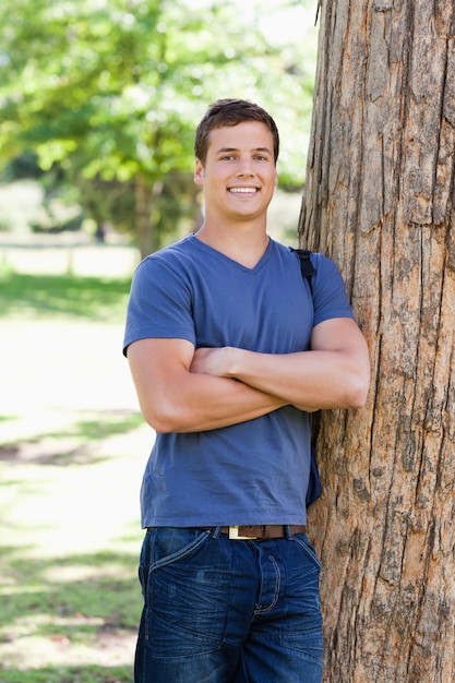 Portrait of a muscled student next to a tree