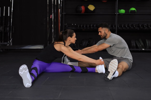 Portrait of a muscular couple doing leg stretchings