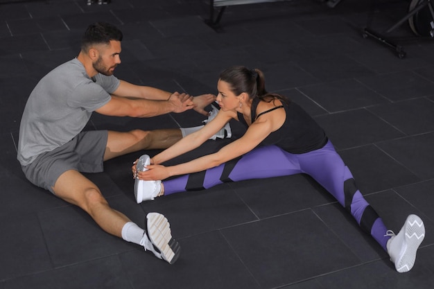 Portrait of a muscular couple doing leg stretchings