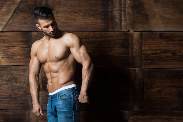 Portrait of Muscular Man Standing Near the Wall