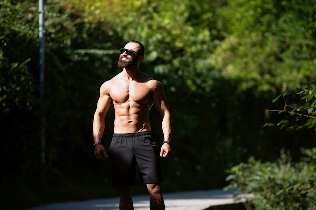 Portrait of Muscular Man Standing Strong Outdoors