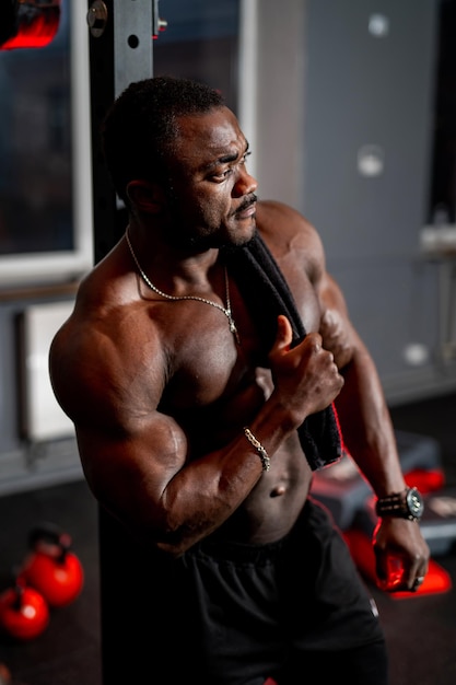 Portrait of a muscular man without shirt after heavy workout Happy bodybuilder poses to the camera