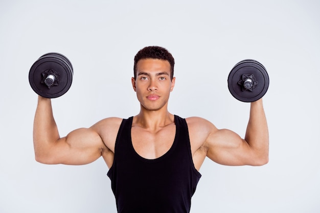 portrait of muscular sportive perfect macho guy doing exercise lifting weight dumbbell