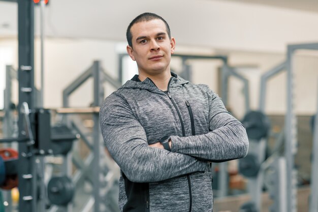 Portrait of muscular sporty man with folded hands