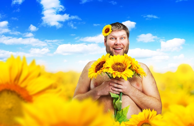 Ritratto di uomo nudo in un campo di girasoli