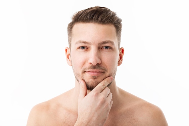 Portrait of a naked young man with stubble on a white background