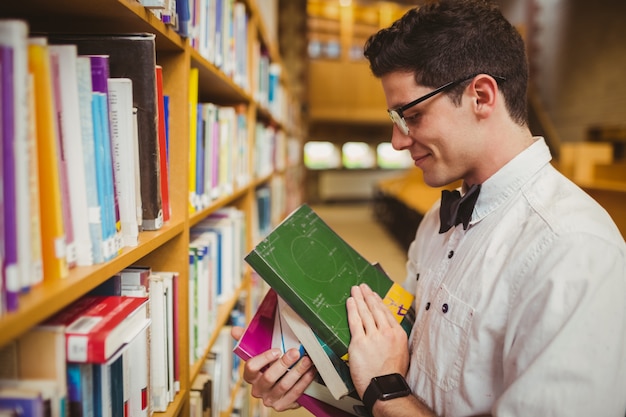 Portrait of nerd holding books in library