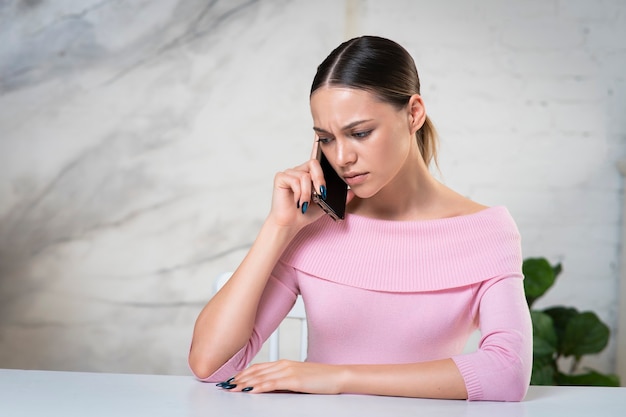 Portrait of nervous frustrated sad upset young woman disappointed girl calling talking on cell