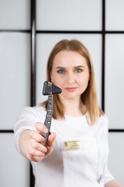 Photo portrait of a neurologist with a neurological hammer in his hand