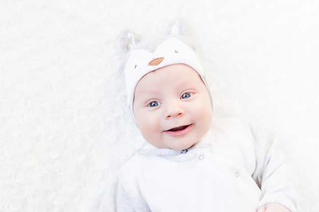 Portrait of a newborn in a hat with ears on a white