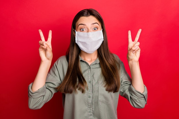 portrait of nice attractive girl wearing safety mask showing double v-sign