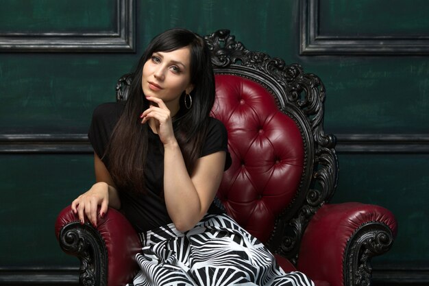 Portrait of a nice beautiful woman sitting in a beautiful expensive chair