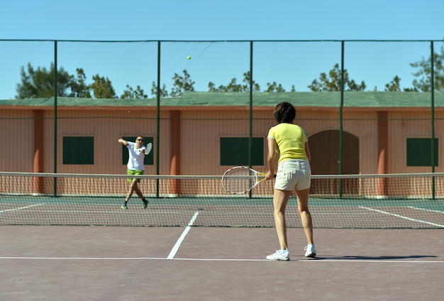 Portrait of a nice couple playing tennis outdoors