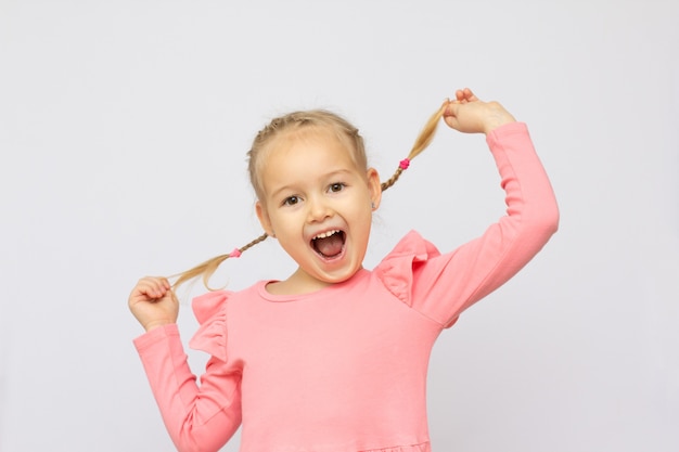 Portrait of nice cute lovely attractive adorable girlish cheerful cheery positive funny school girl playing with curls opened mouth isolated over white background