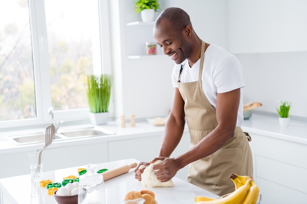 Portrait of nice guy confectioner making fresh bread pie doughing flour learning