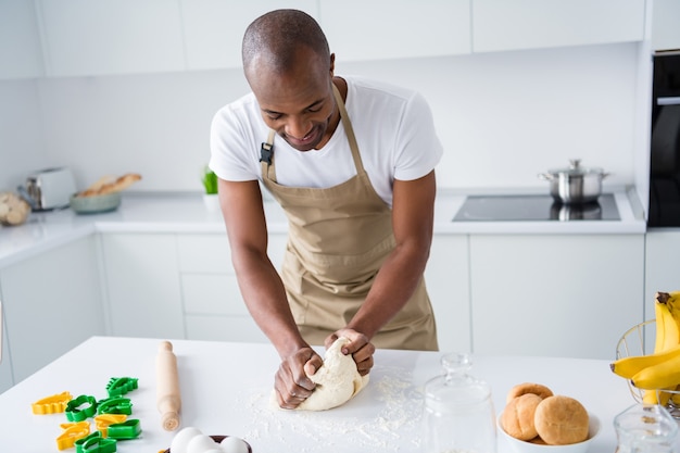 Portrait of nice guy confectioner making fresh bread pie doughing flour learning