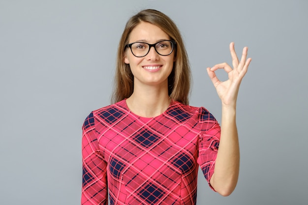 Portrait of nice lady showing okey symbol