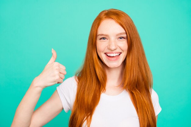 Portrait nice redhead girl isolated over turquoise wall