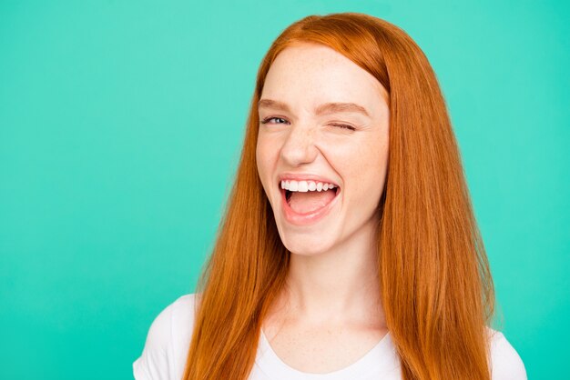 Portrait nice redhead girl isolated over turquoise wall