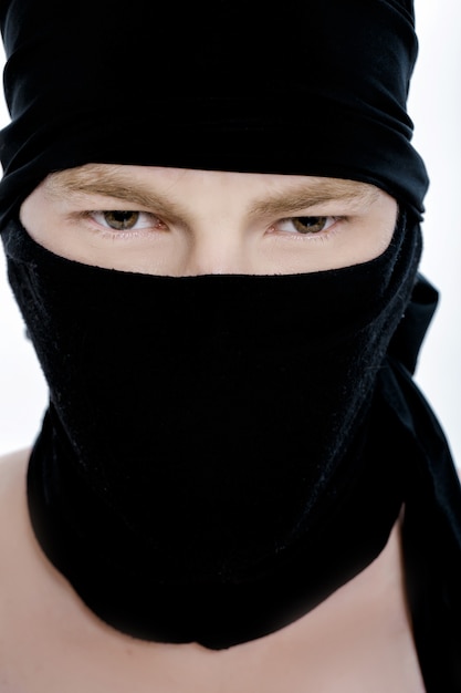 Ritratto di uomo ninja in una maschera nera su sfondo bianco