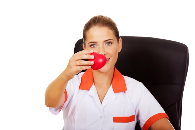 Photo portrait of nurse holding heart shape while sitting at table against white background