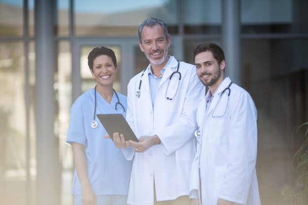 Portrait of nurse and surgeon using digital tablet