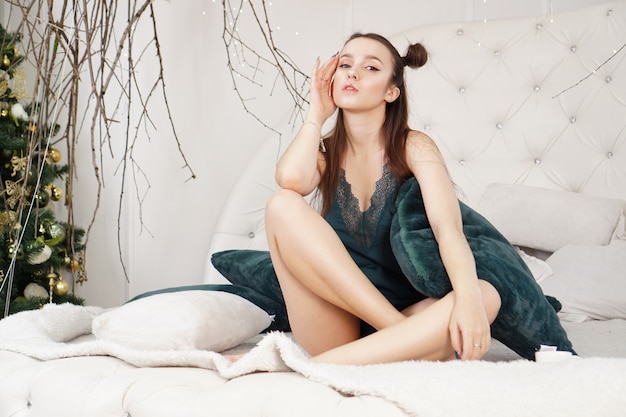 Фото Портрет красивой девушки в пеньюаре красивая сексуальная дама на кровати в своей спальне фотомодель в помещении женское нижнее белье счастливое утро