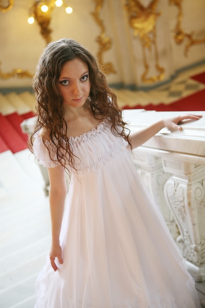 사진 흰 드레스에 아름 다운 젊은 빅토리아 여자의 초상화입니다. 러시아 궁전입니다.