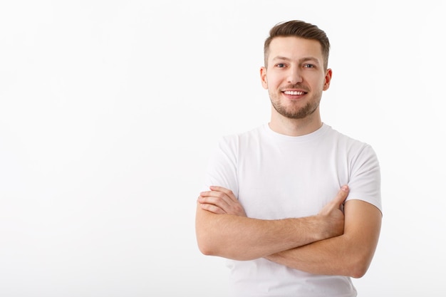 Фото Портрет веселого молодого человека в белой футболке на белом фоне парень стоит, смотрит в камеру и улыбается