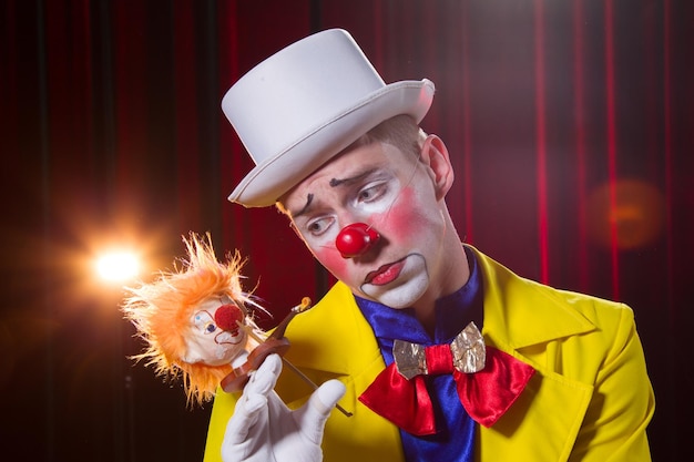 Фото Портрет циркового клоуна мужчина в костюме клоуна с игрушкой