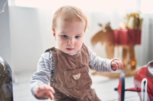 床に座っているかわいい1歳の男の子の肖像画。