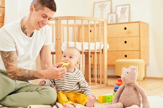 写真 お父さんと一緒に部屋で遊んでいるかわいい小さな子供の肖像画