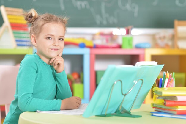 Фото Портрет милой школьницы, делающей домашнее задание