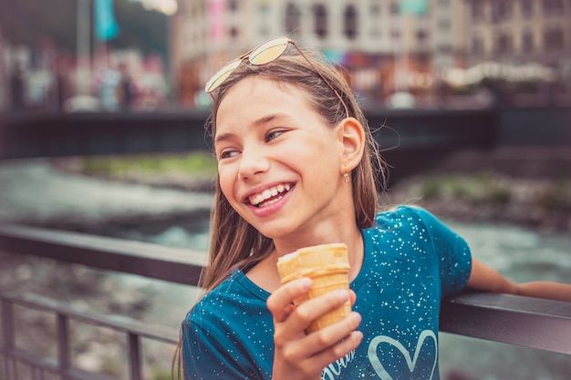 写真 街の通りで手にアイスクリームと幸せな子供の肖像画。