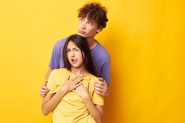 友情の楽しい黄色の背景を変更せずにポーズをとるカラフルなtシャツの男性と女性の肖像画