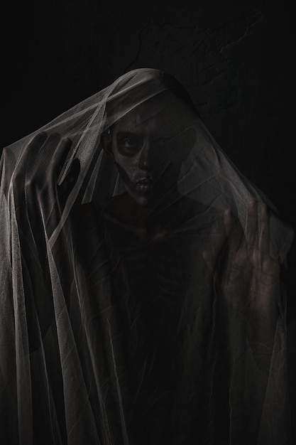 Фото Портрет страшного человека в вуале крупным планом на темном фоне костюм призрака на хэллоуин
