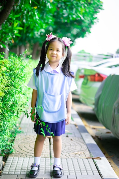 写真 歩道に立っている笑顔の女の子の肖像画