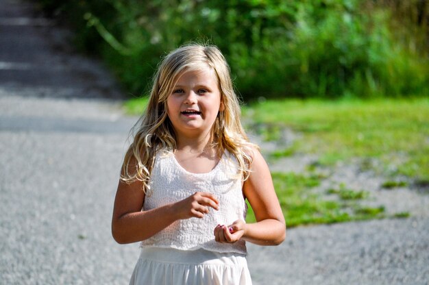 写真 外に立っている笑顔の女の子の肖像画