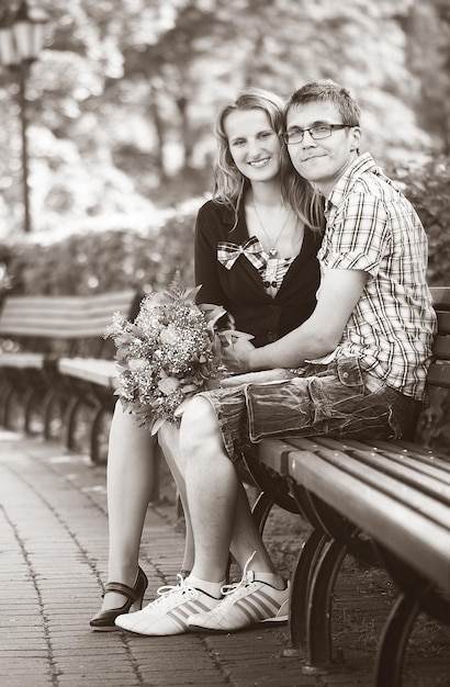 写真 公園に座っている笑顔の若い夫婦の肖像画