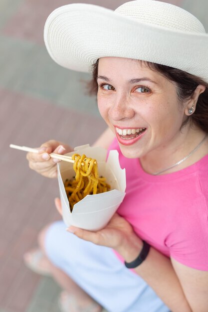 写真 食べ物を握っている笑顔の若い女性の肖像画