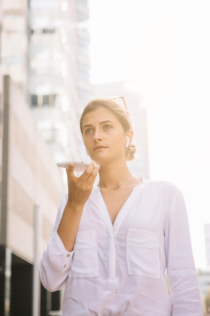 写真 スピーカーを通して携帯電話で話している若い実業家の肖像画