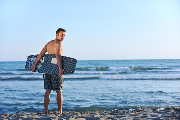 사진 해가 지는 해변 에서 젊은 키트 서프 남자 의 초상화