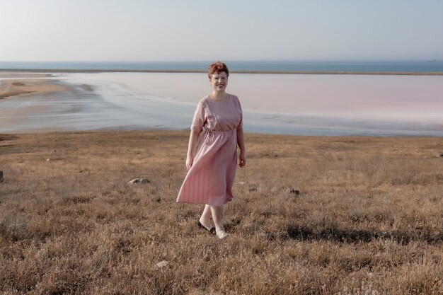 Фото Портрет молодой женщины в розовом платье в поле
