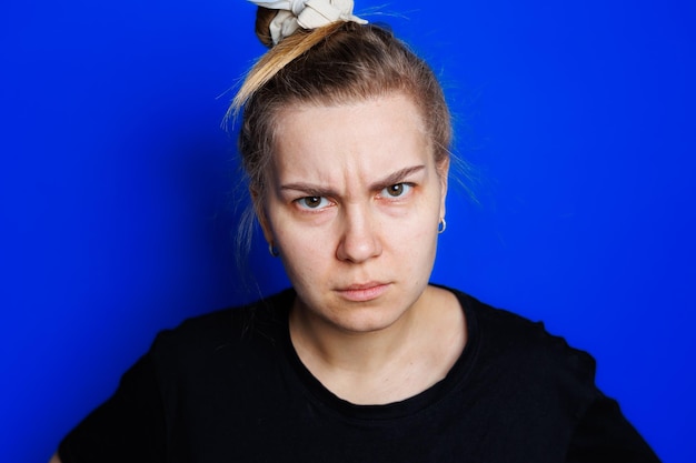 Фото Портрет молодой женщины на синем фоне, держащей голову головная боль мигрень у женщины