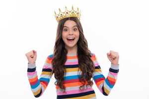 portrait of ambitious teenage girl with crown feeling princess confidence child princess crown on isolated studio background excited face cheerful emotions of teenager girl