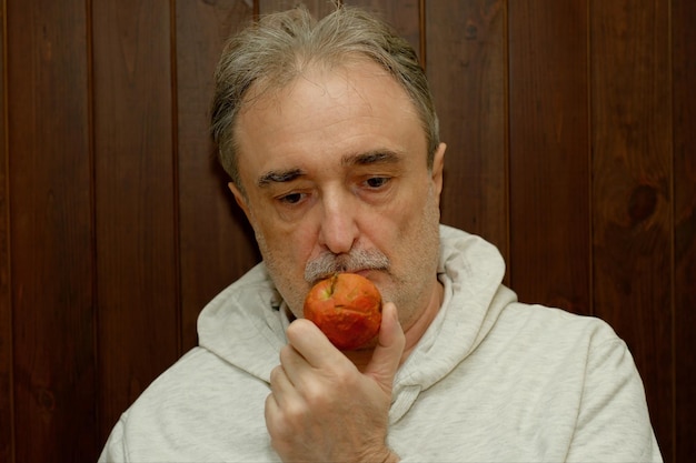 사진 갈색 에 사과 를 입은 가 ⁇ 운 후디 를 입은  ⁇ 수염 을 가진 나이 든 면도 하지 않은 남자 의 초상화