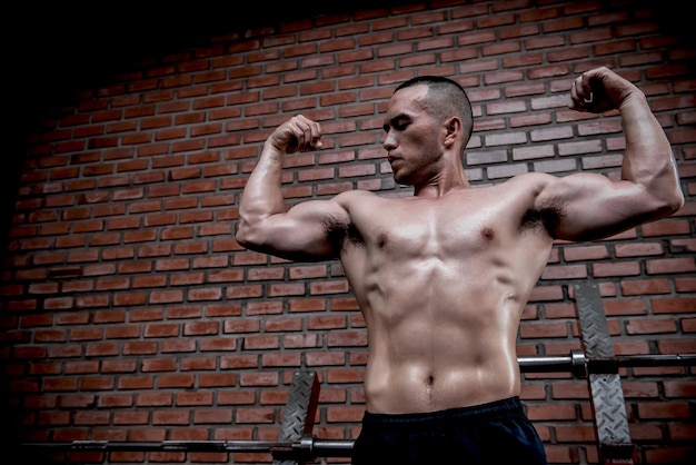 Фото Портрет азиатского мужчины с большими мышцами в тренажерном залетаиландцытренировка для хорошего здоровьятренировка с весом телафитнес в концепции тренажерного зала