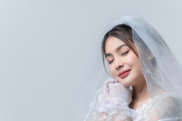 Фото Портрет азиатской женщины носить невесты с цветком на белом фонесвадебная концепция