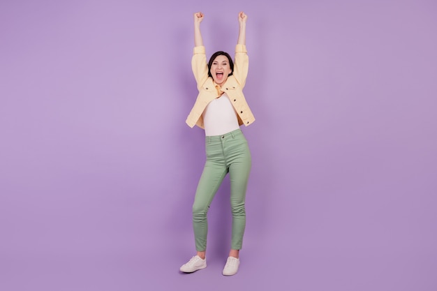写真 驚いた狂気の少女の陽気な反応の肖像画口を開けて紫色の背景に手を上げる