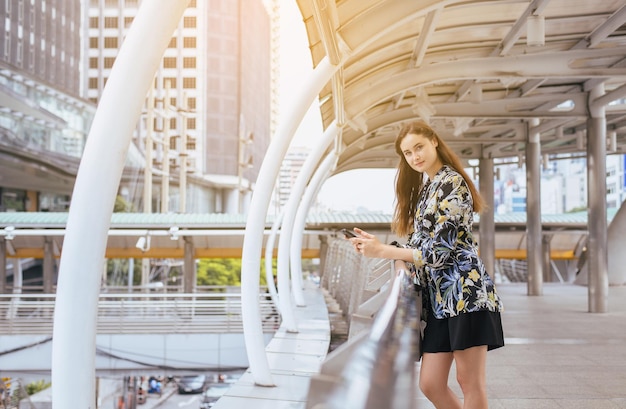 写真 携帯電話を使用してカメラを見ている美しい女性の肖像画